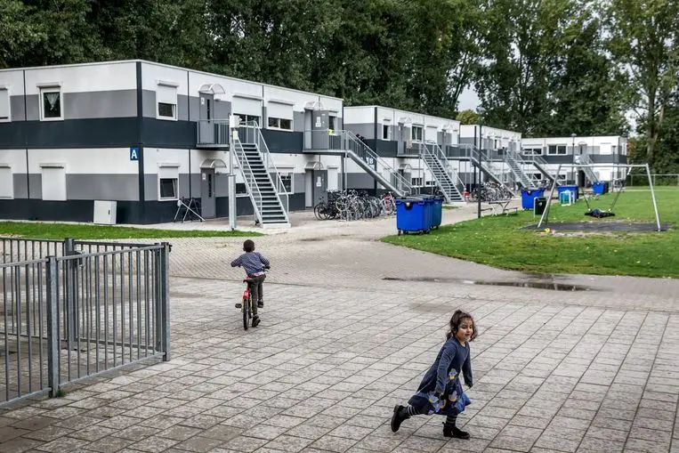 Two children walk around the grounds of a refugee reception centre