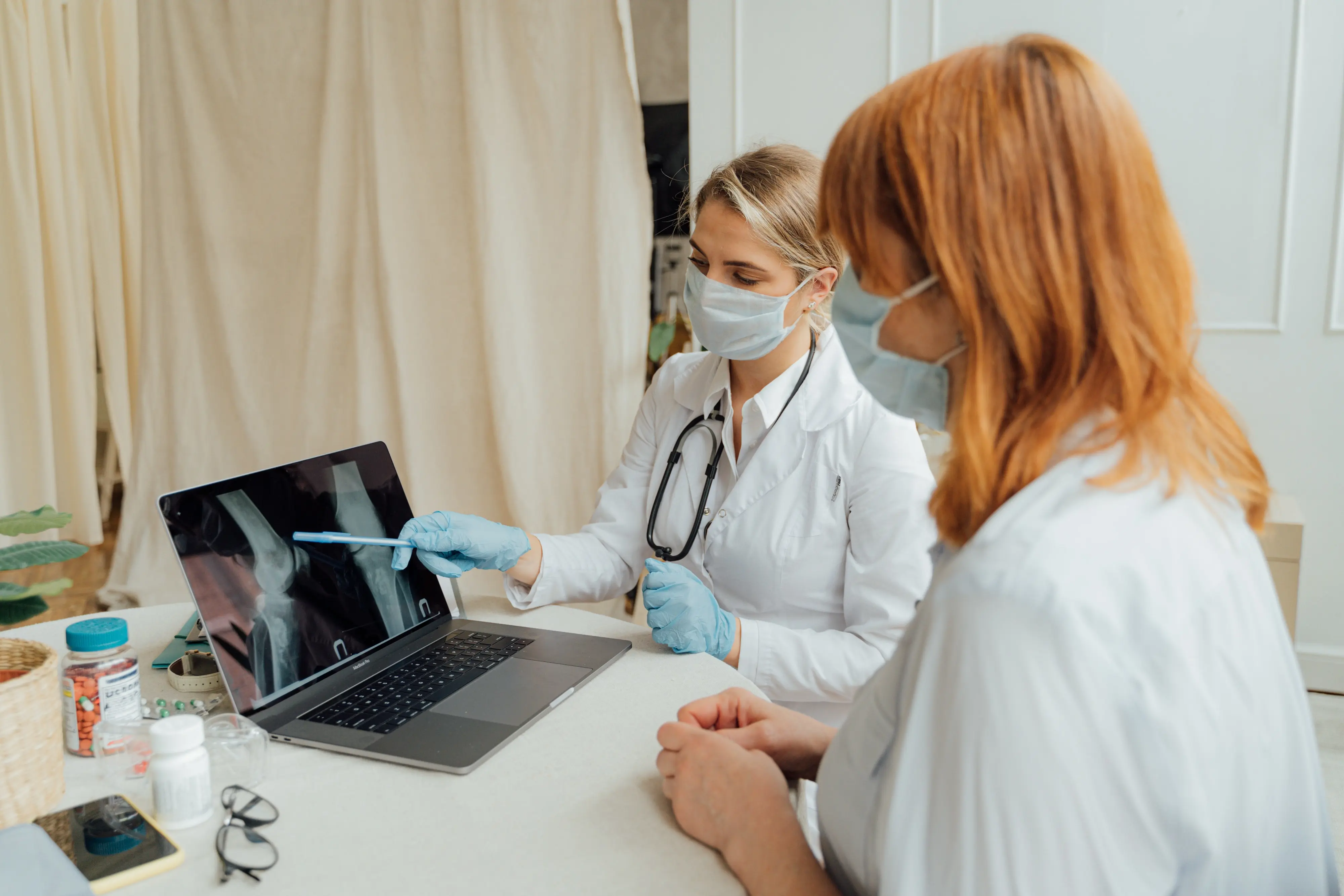 Two doctors view an x-ray on a laptop