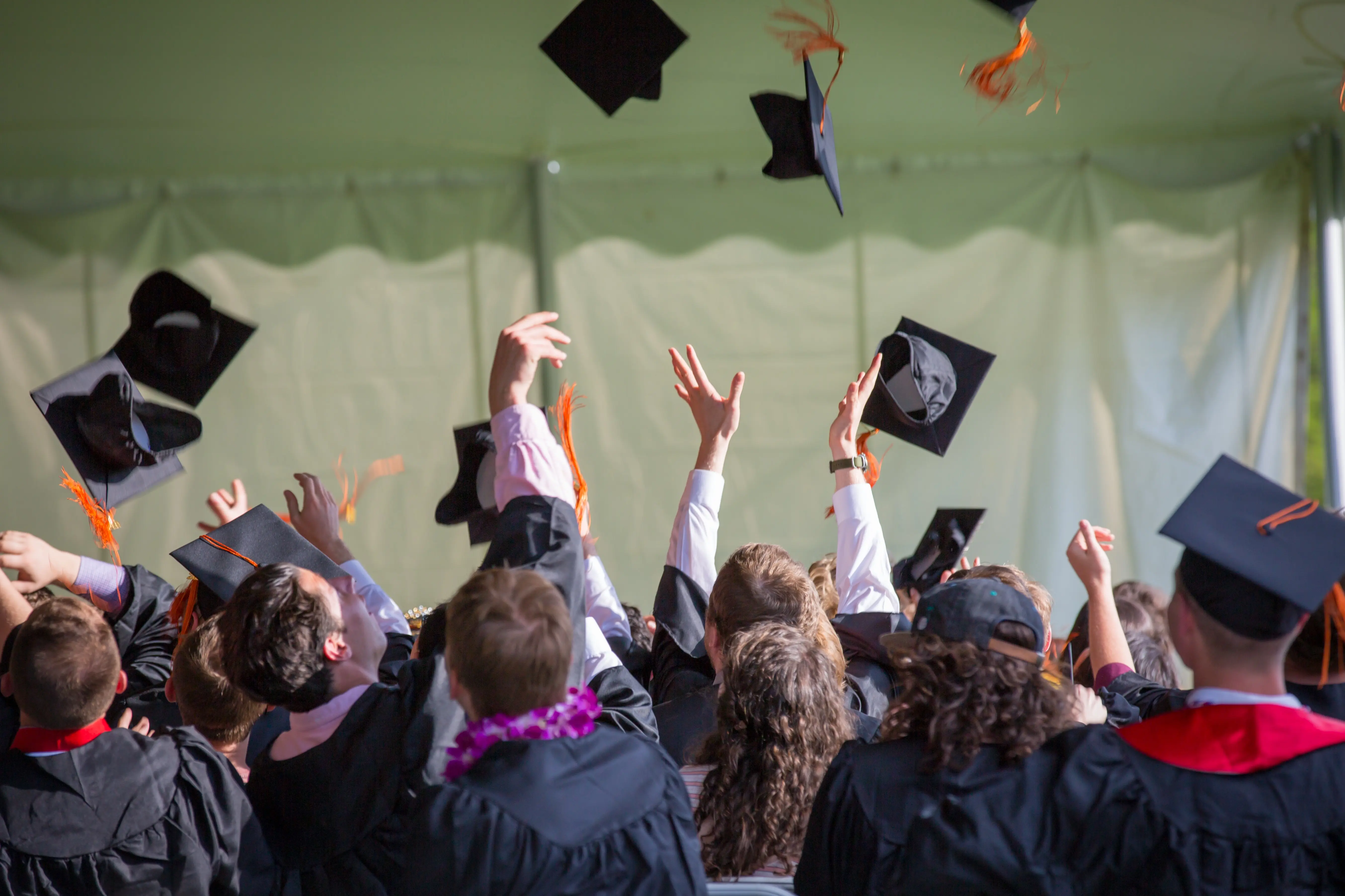 Students throw their graduation hat in the air