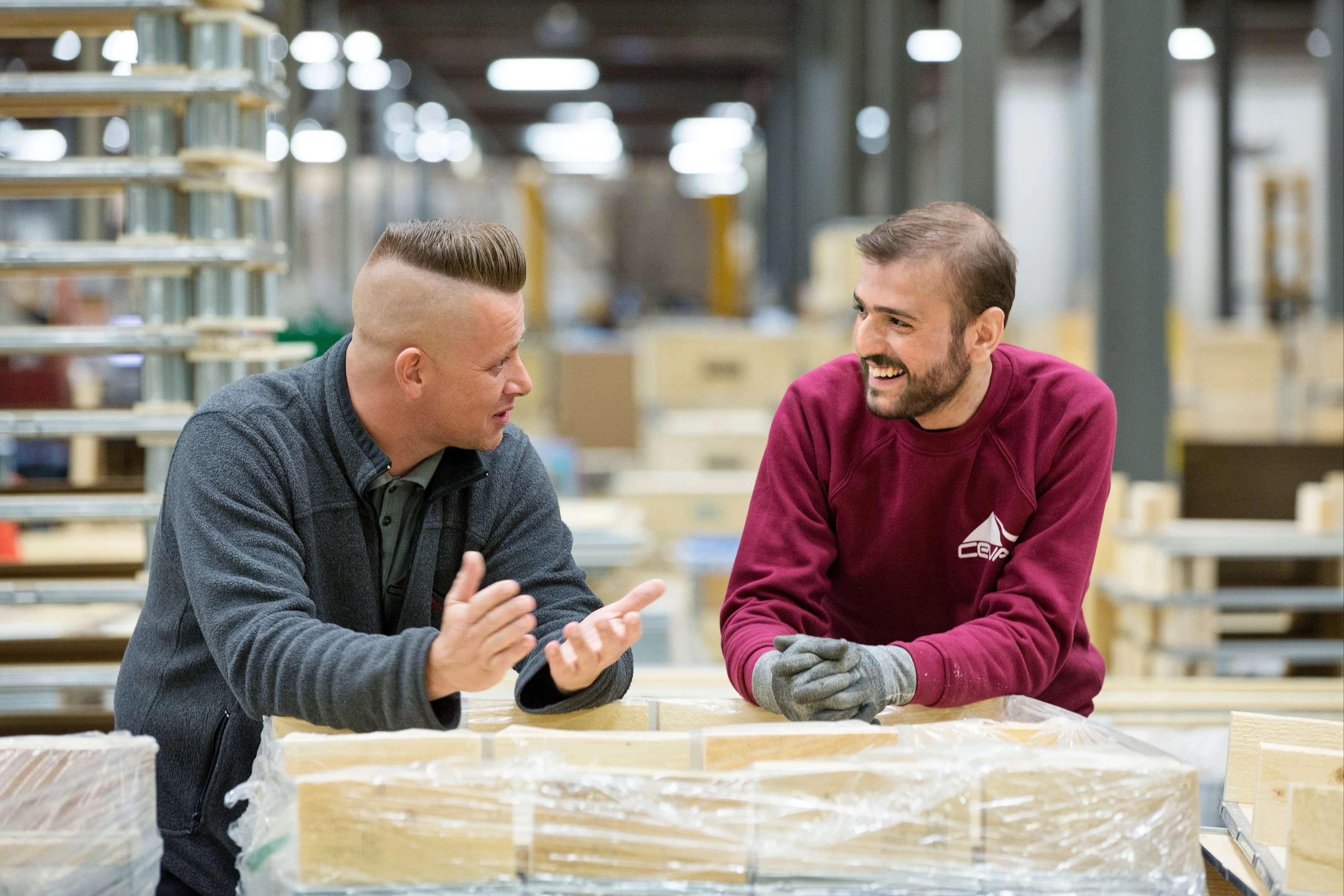 A man is talking to his employer in a warehouse.