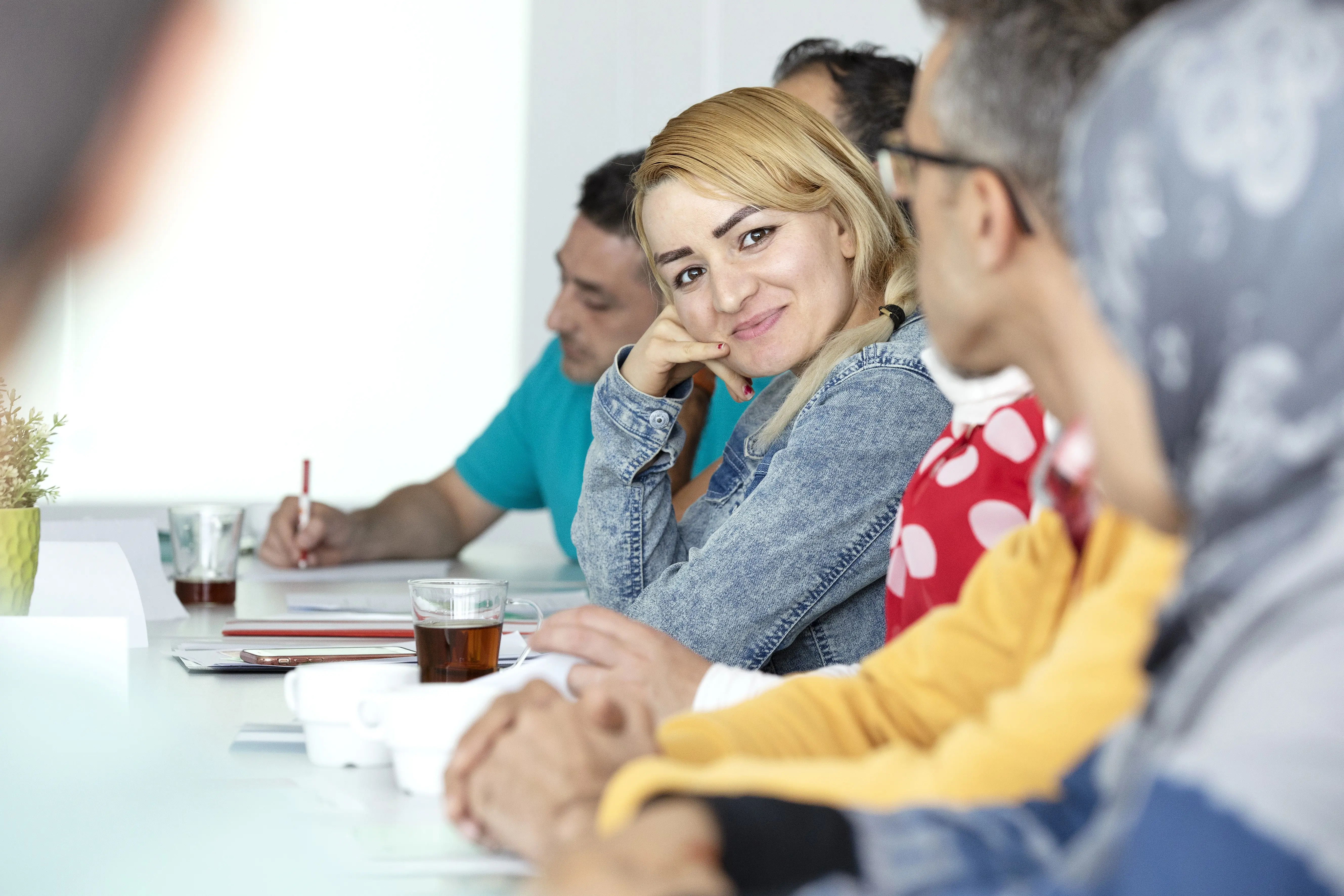 Une femme assise dans la classe qui regarde la caméra en rigolant