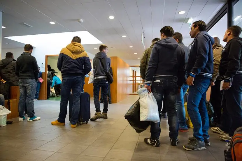 Vluchtelingen staan in de rij voor hun aanmelding in Nederlandse dorp Ter Apel