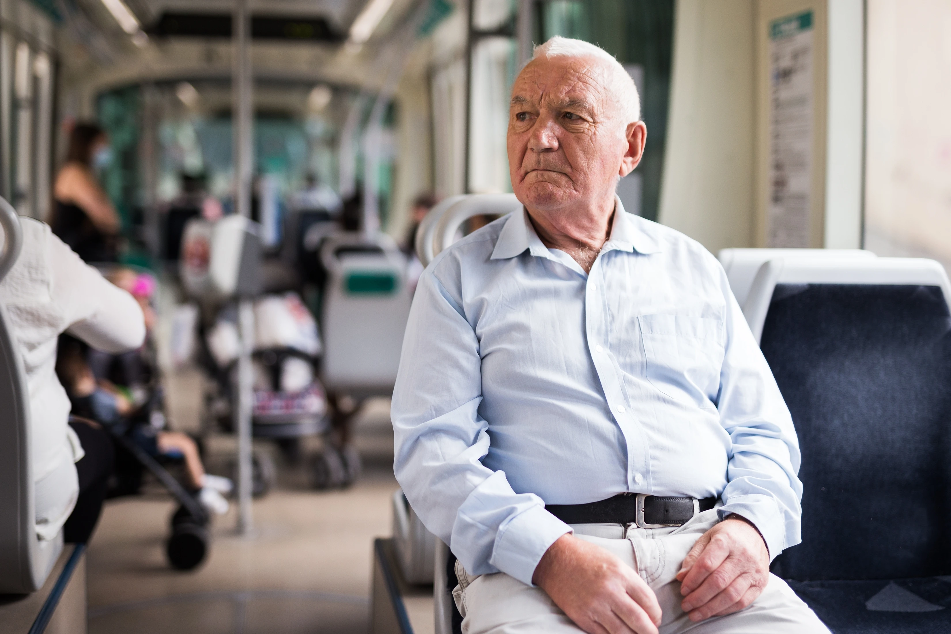 An old man sits in a tram