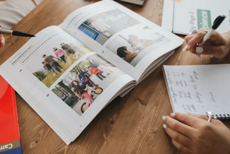 Iemand leert de Nederlandse taal uit een boek met afbeeldingen