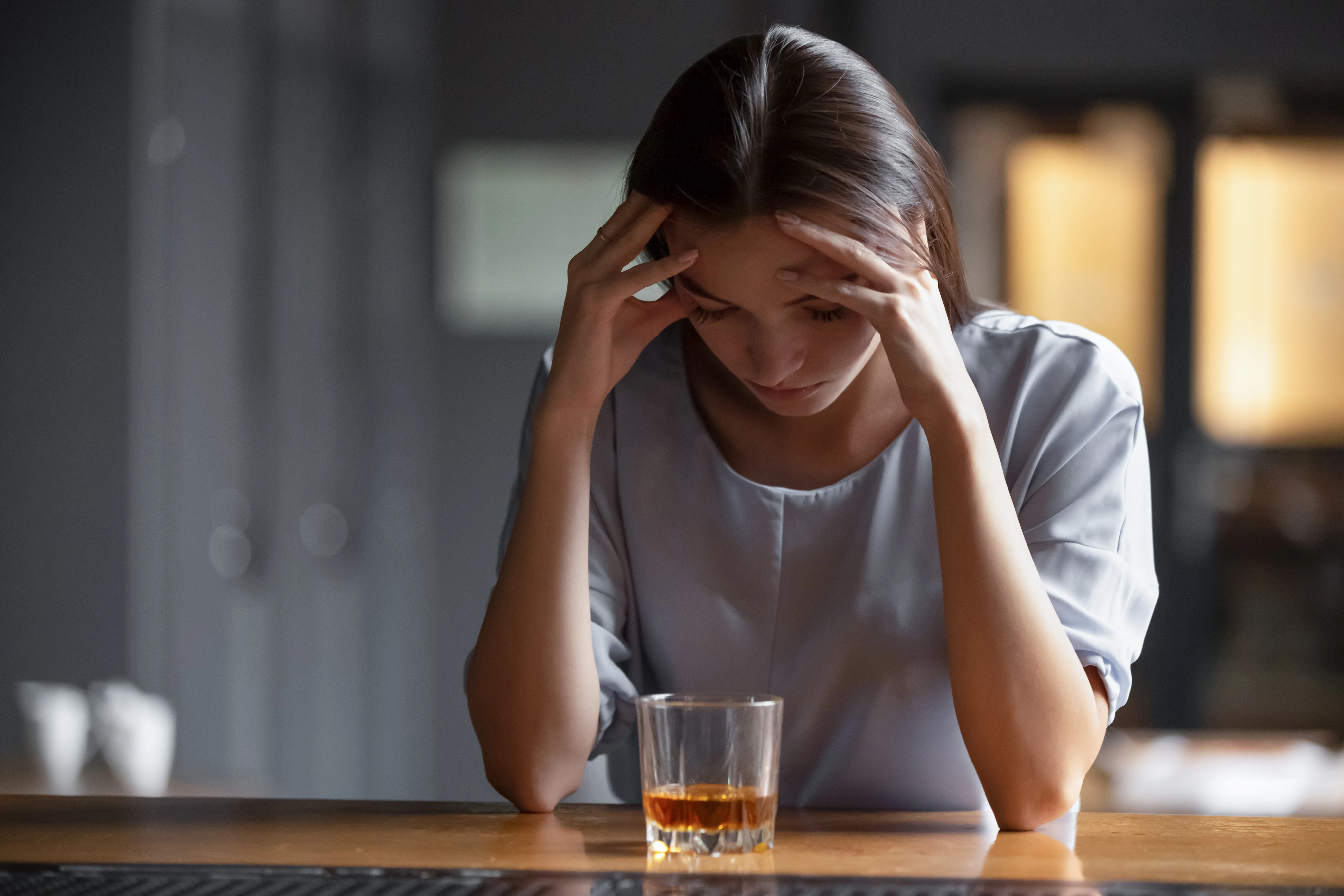 Vrouw aan de bar met een glas alcohol