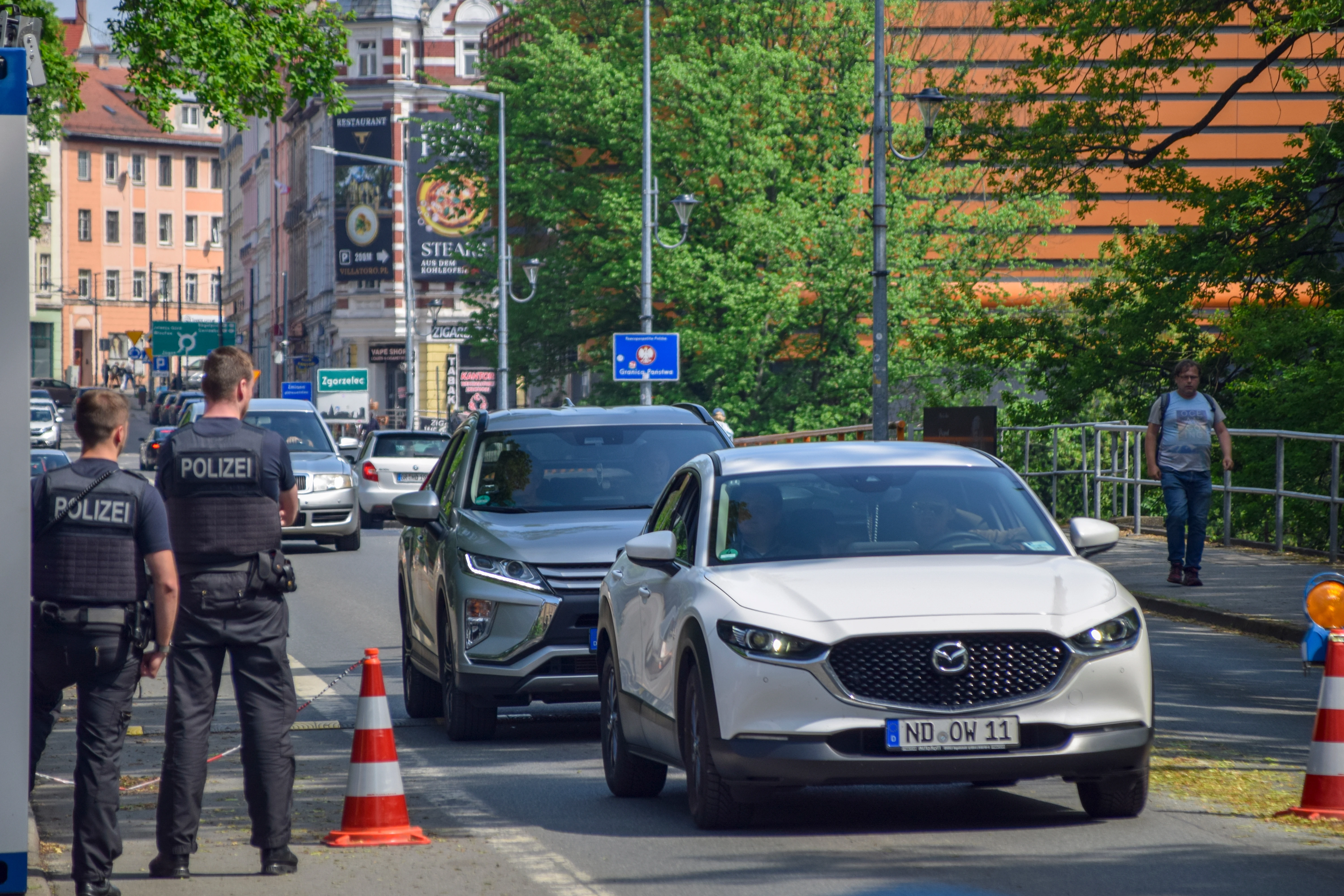 Duitse politieagenten controleren mensen die de grens over willen steken tussen Nederland en Duitsland. 