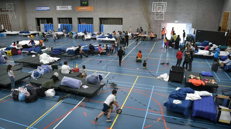 People in a crisis emergency reception centre in a sports hall