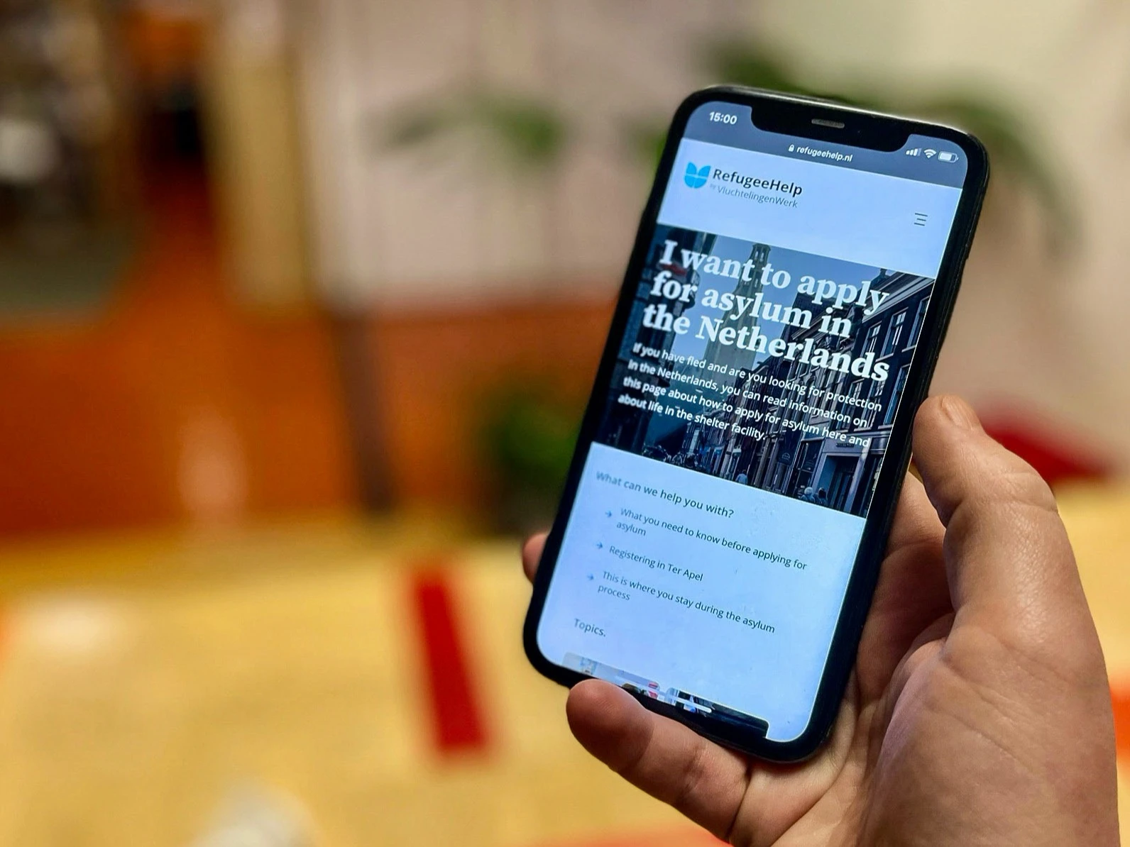 Telefoon met daarop de splashscreen van RefugeeHelp