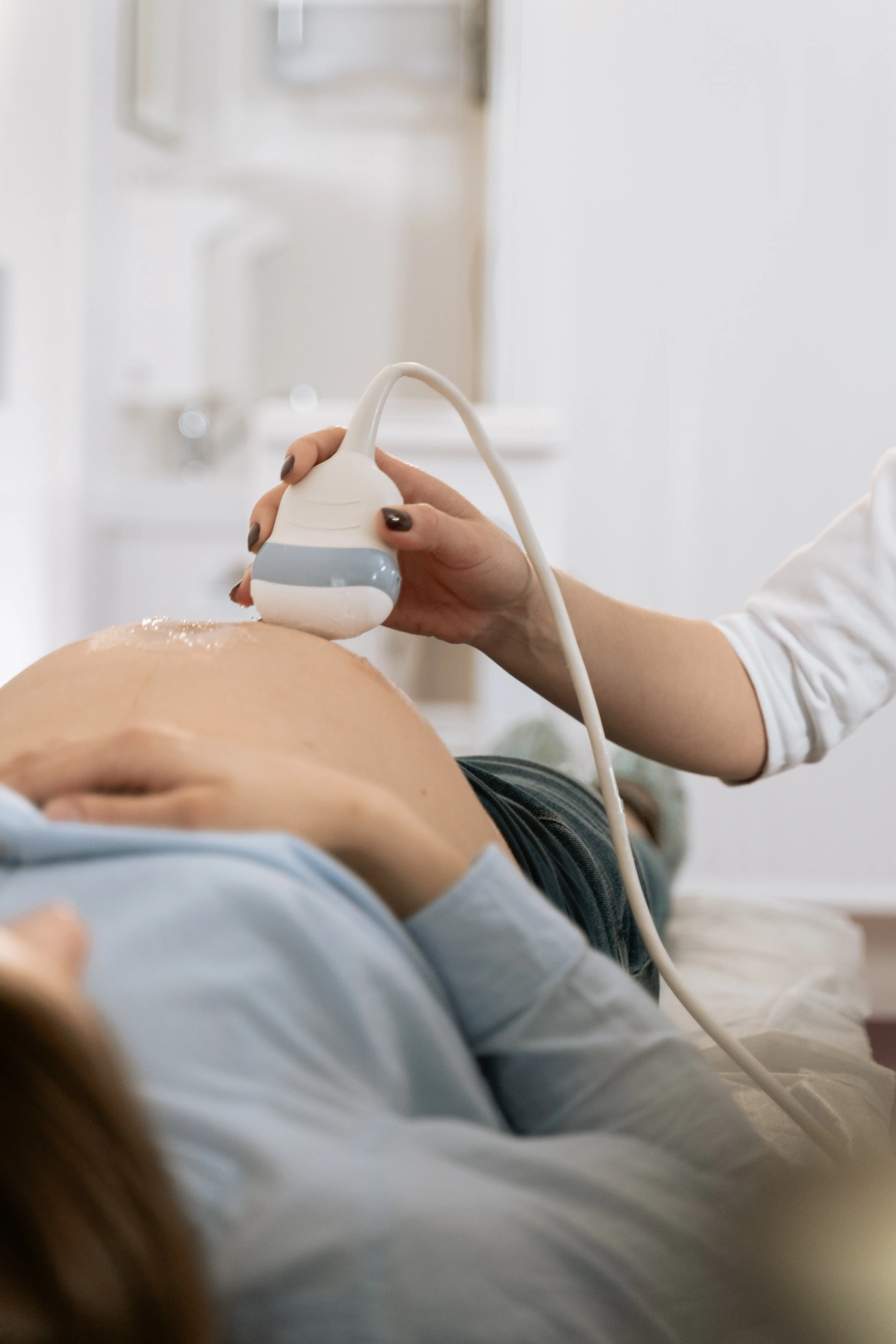 Zwangere vrouw wordt onderzocht met een echoapparaat 