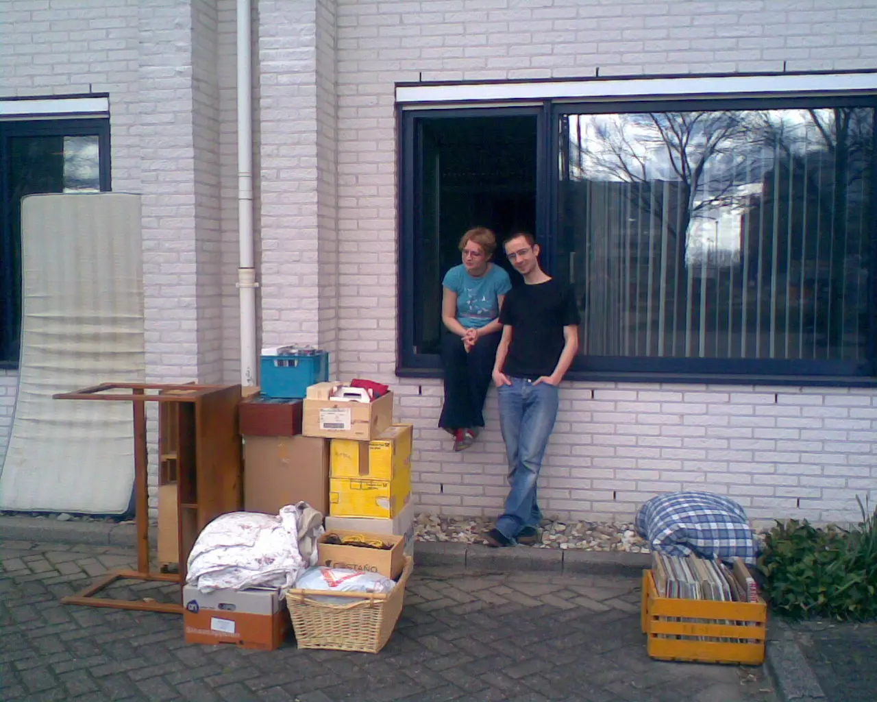 A woman and a man together lift a large removal box