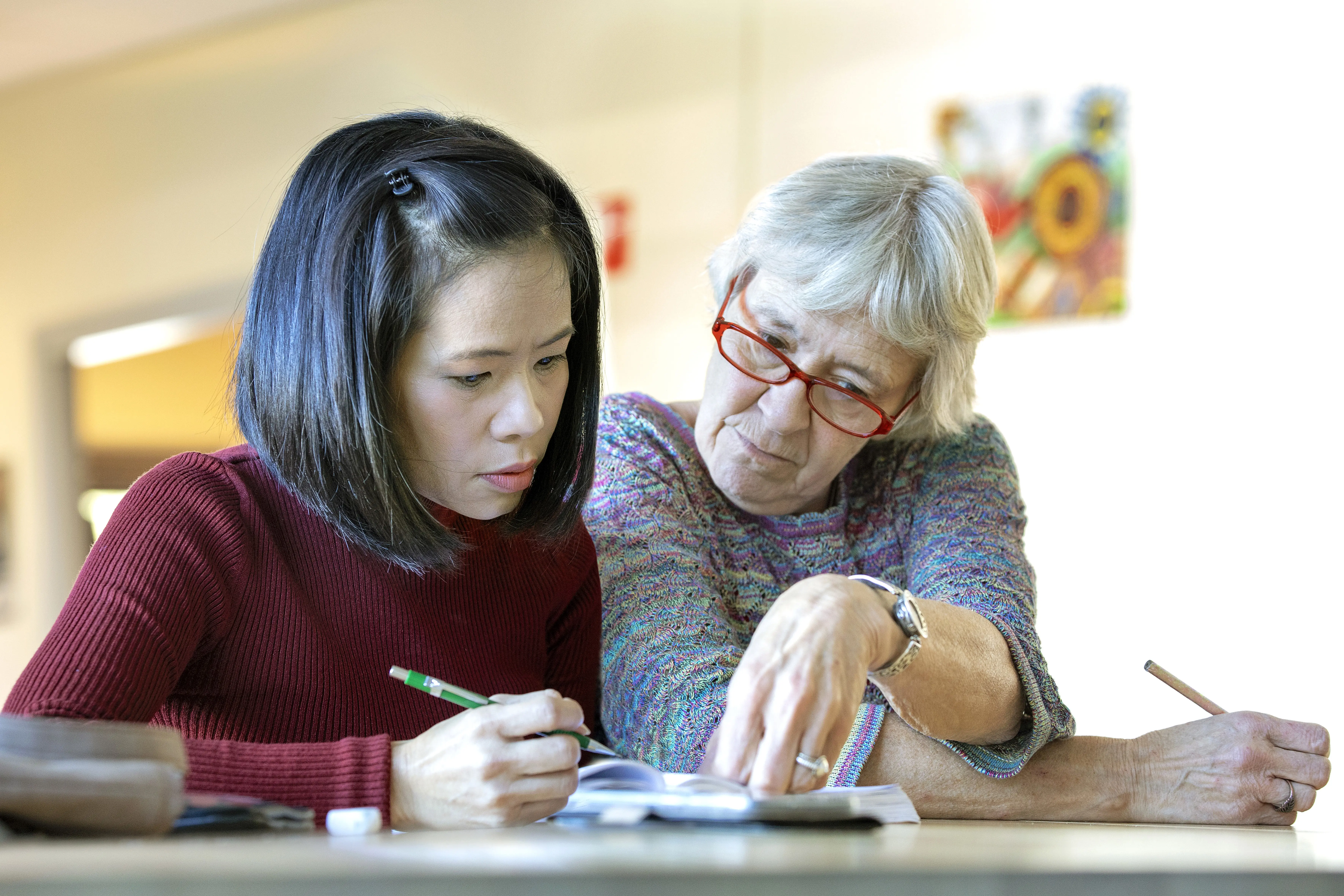 Een vrouw wordt ondersteund bij het invullen van documenten door haar contactpersoon bij VluchtelingenWerk Nederland.