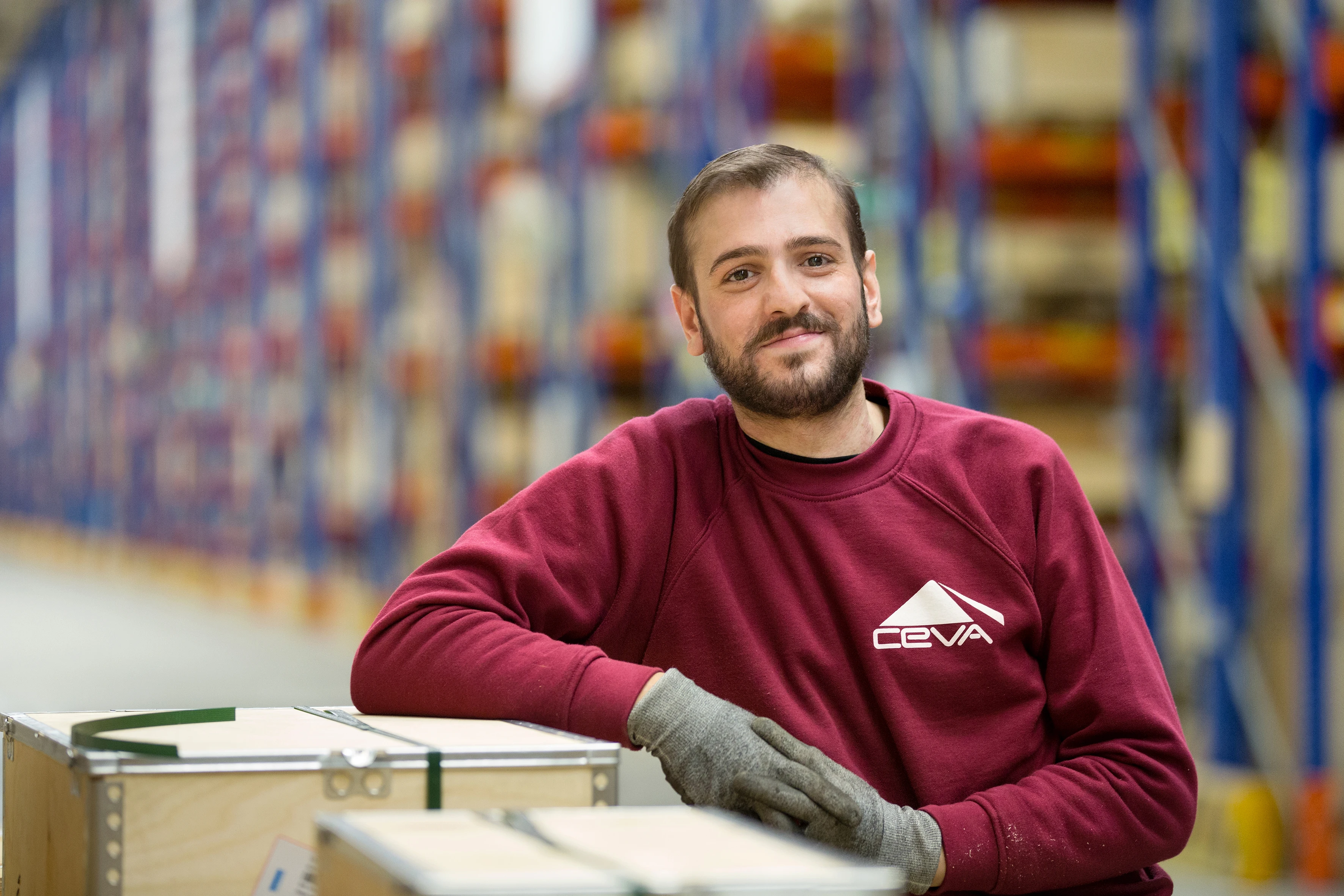 A man smiles as he works in the warehouse.