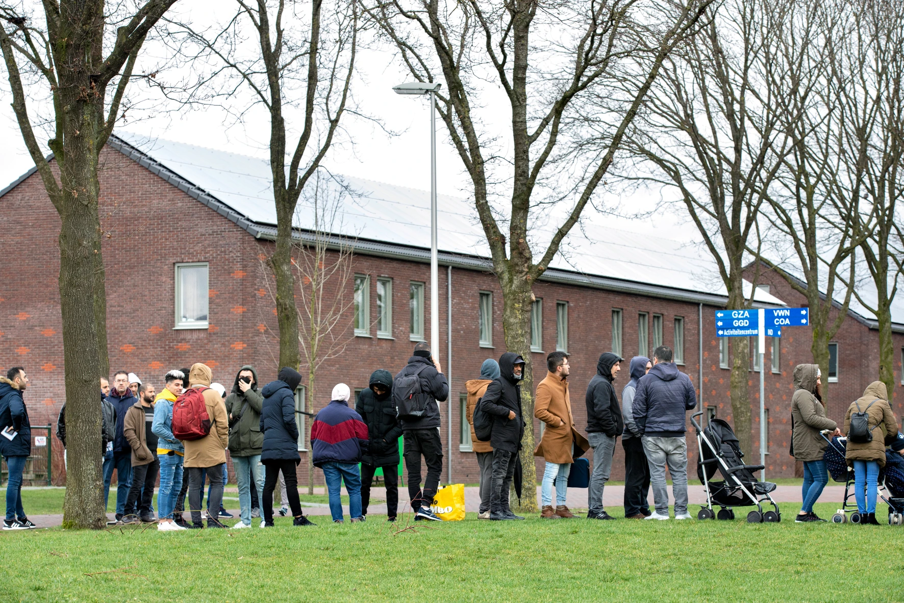 صفی از مردم در ورودی پناهگاه در دهکده هلندی تر آپل منتظر هستند.