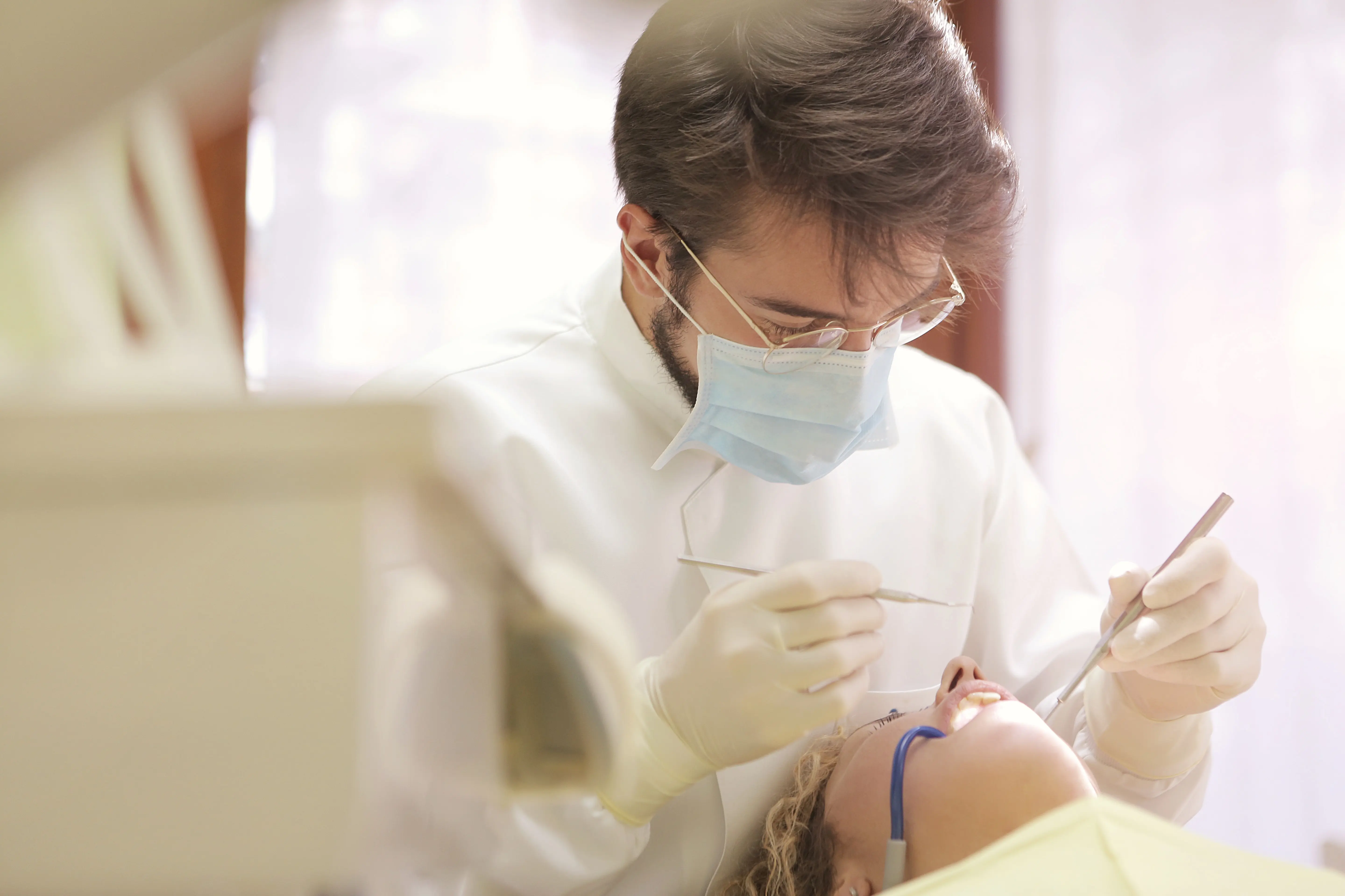 A dentist checks a client's mouth