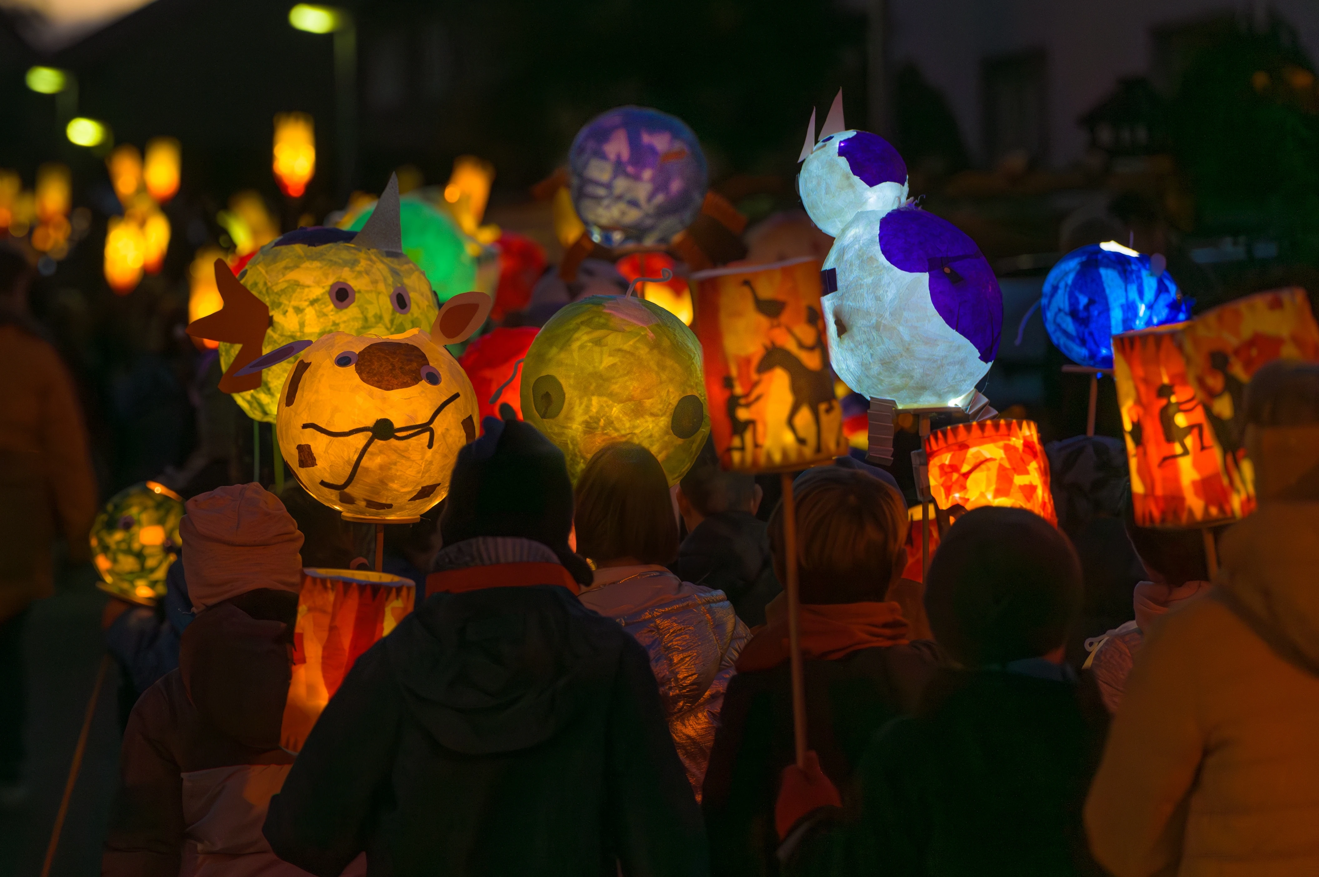 A group of people walk the streets with lanterns. They are celebrating St. Martin's Day.