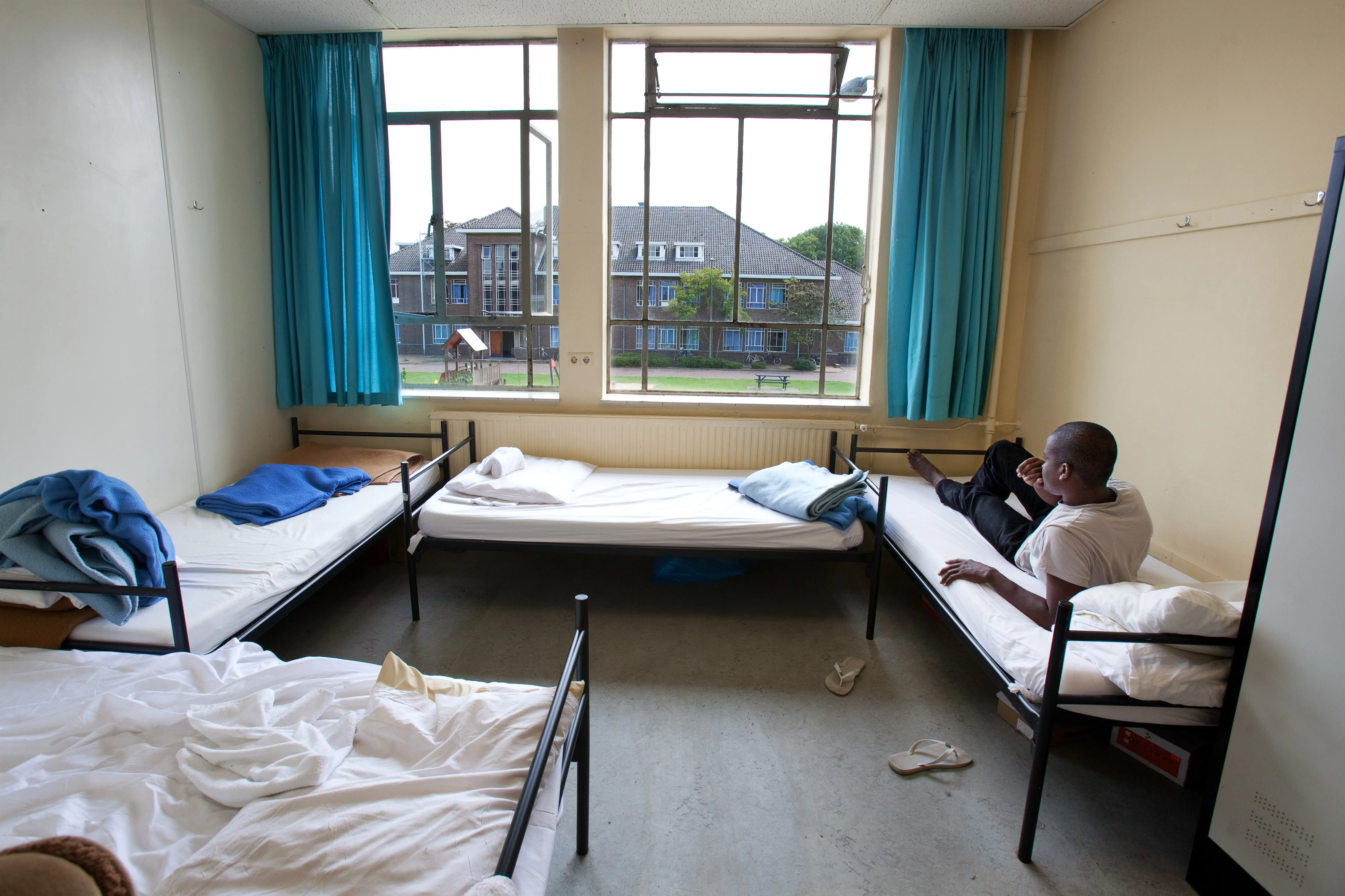 A man waiting in an asylum reception centre.