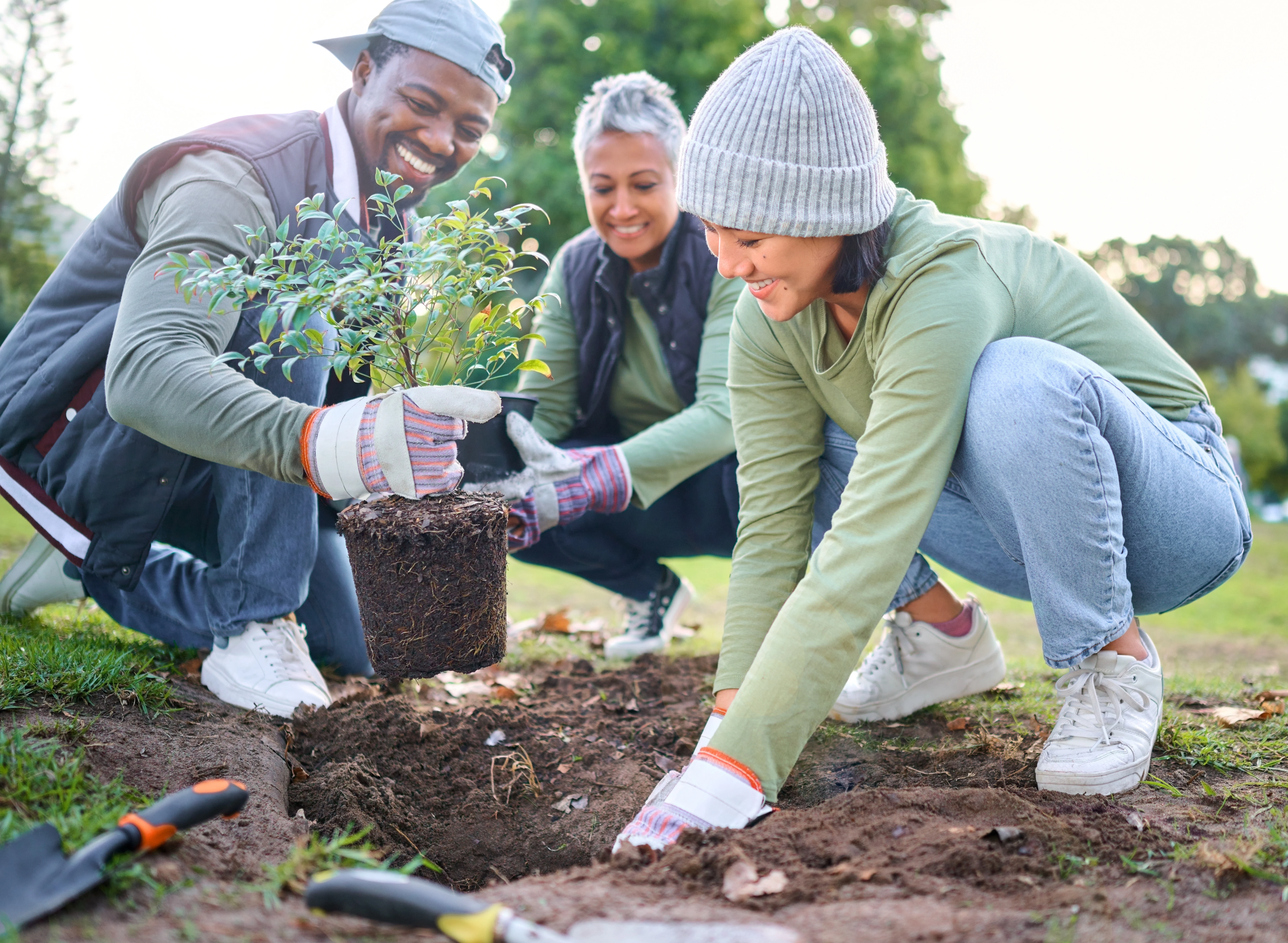 Vrijwilligers planten een boom in een gemeenschappelijke tuin.