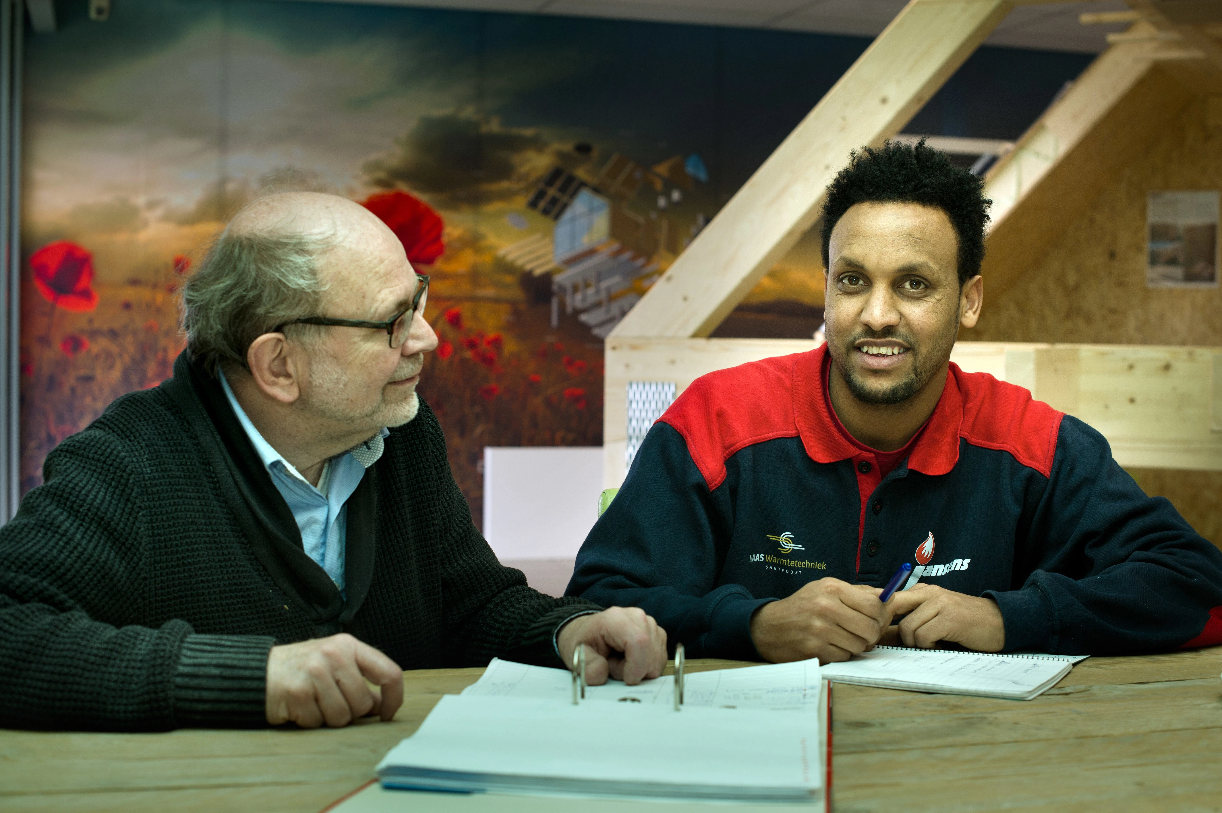 Deux hommes assis autour d'une table.