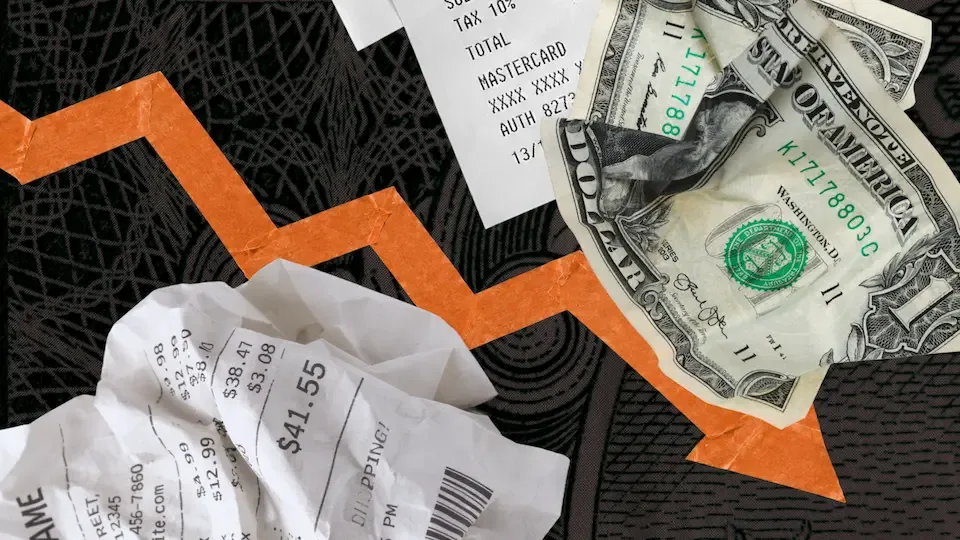 Crumpled receipts, cash, and credit card slip on dark surface with orange downward arrow indicating financial decline.