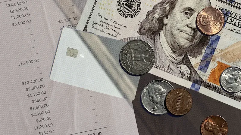Financial planning scene with hundred dollar bill, coins, credit card, and budget spreadsheet on desk