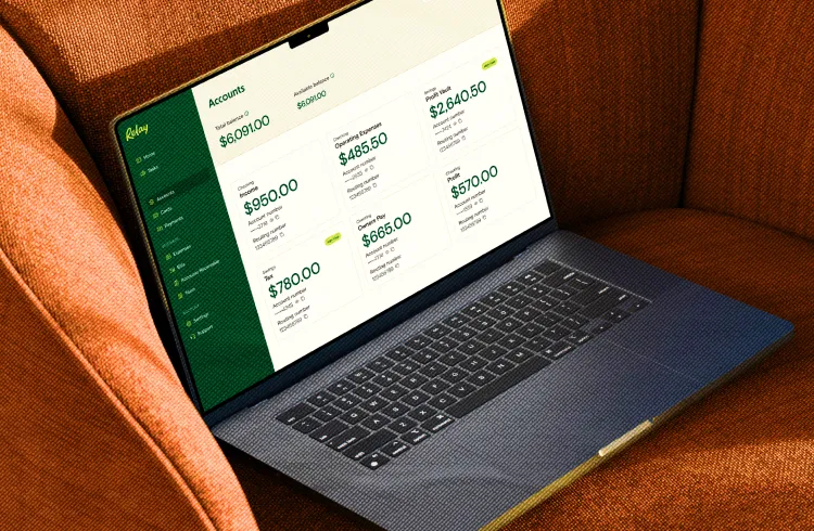 A laptop showing the Relay accounts dashboard, resting on an orange armchair