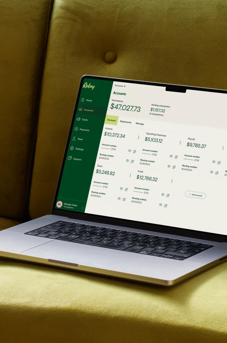 Relay accounts dashboard on a laptop resting on a green couch
