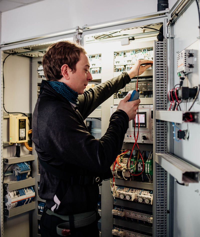 Employé métier électricien Electricien travaillant dans une armoire électrique