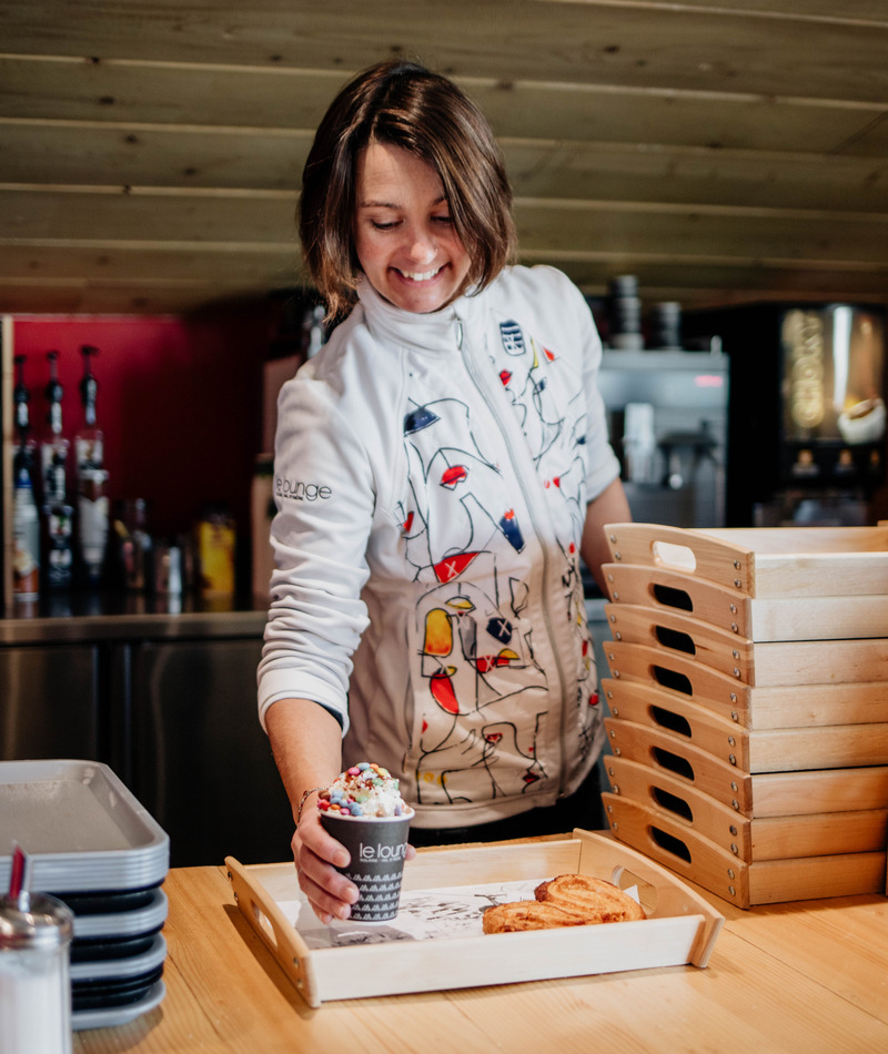 Employée - métier lounge Employée servant une boisson et une viennoiserie sur un plateau
