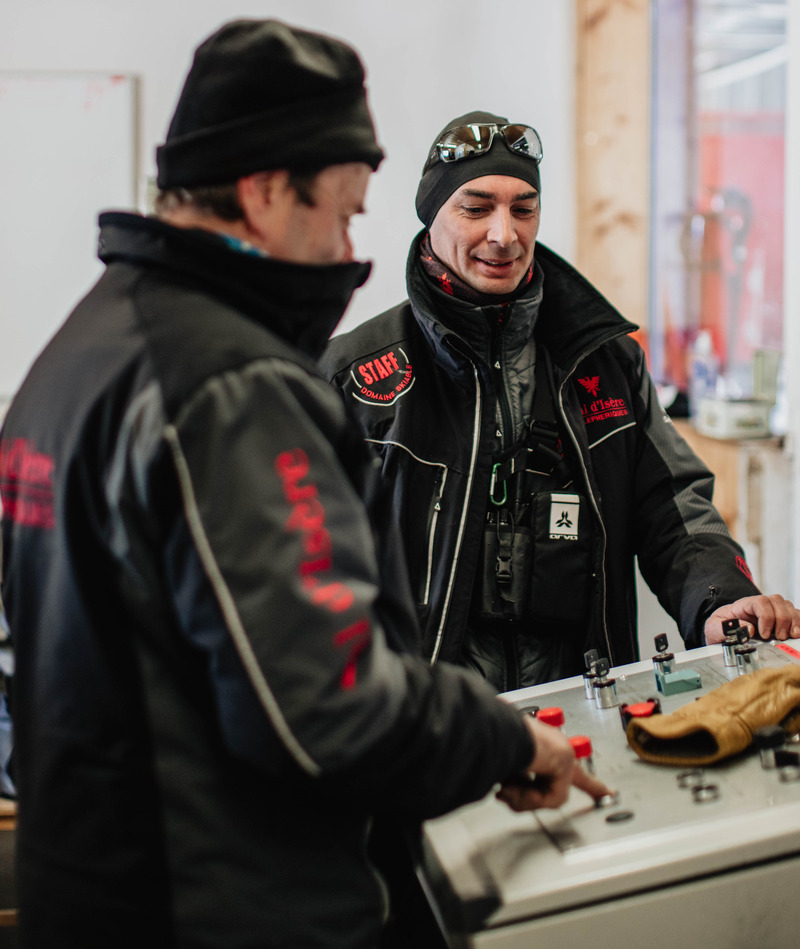 Employé - métier conducteur remontées Chef de massif parlant au conducteur face à pupitre