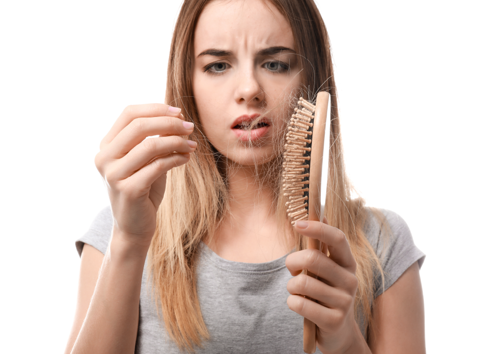 Mujer viendo la pérdida de pelo en su cepillo