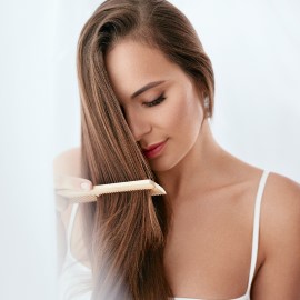 Mujer peinando su cabello largo y liso