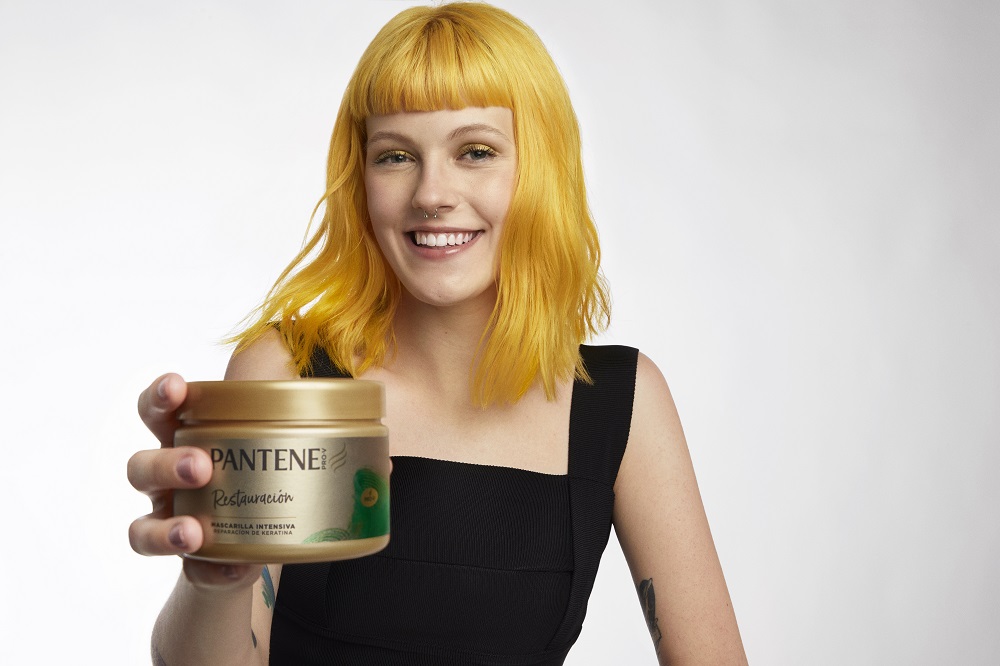 mujer con pelo teñido hidratado con línea Pantene restauración
