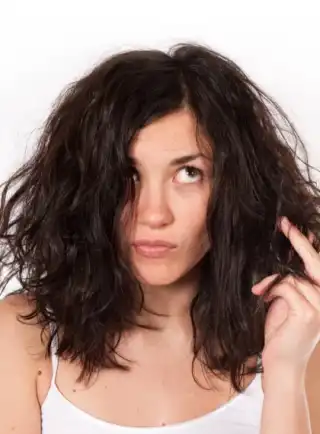 Mujer señalando su cabello maltratado