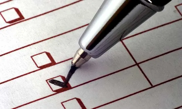 A silver pen is marking a check box on a printed checklist, with several other empty check boxes visible on the page. The checklist appears to be related to veterinary medical tasks or assessments.