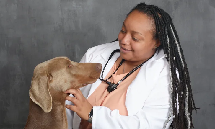 A Black veterinarian with her Doberman.