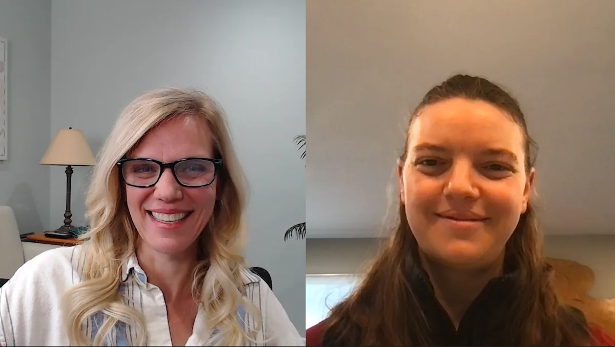 Two women are engaged in a video conference, smiling at the camera. The woman on the left has long blonde hair and glasses, while the woman on the right has long brown hair and is wearing a dark jacket, both appearing to be in well-lit indoor settings.