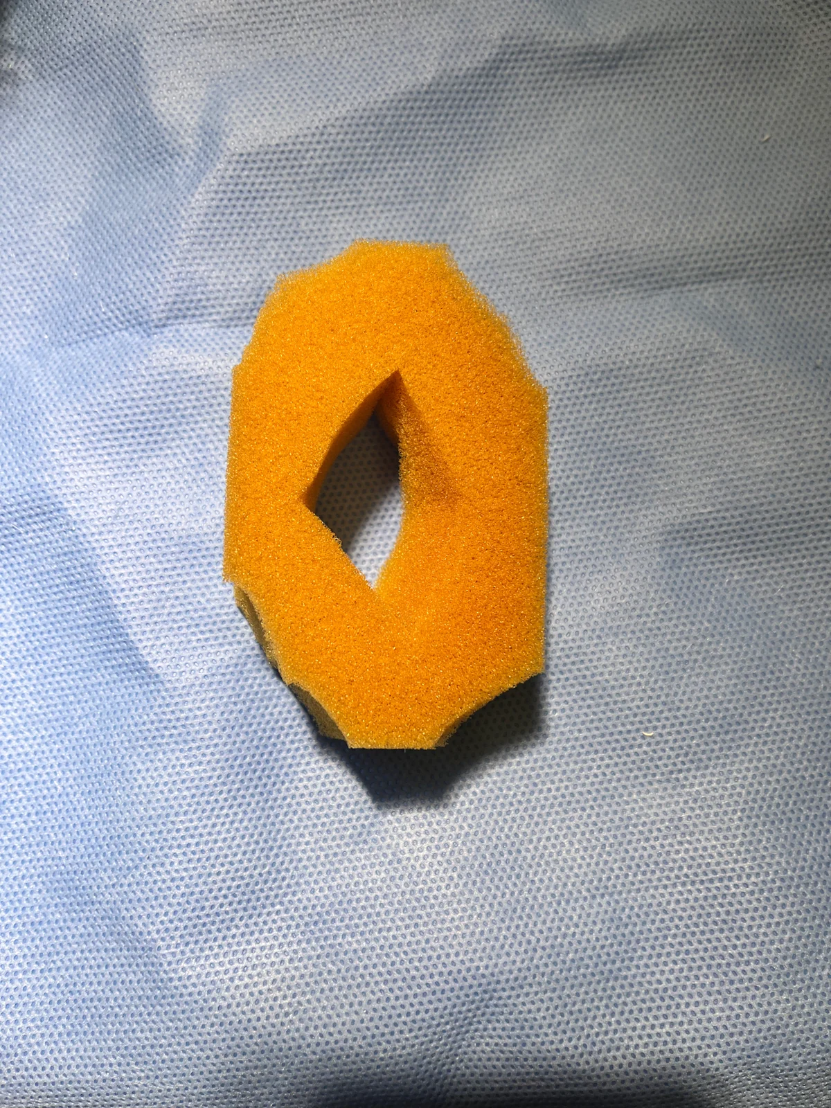 An oval piece of foam with a diamond shape cut out from the center.