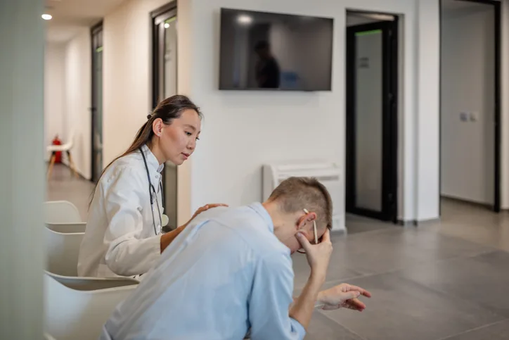 A veterinarian consoling another person.