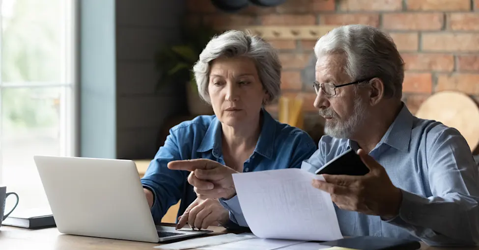 Senior couple looking at medical bills on the computer