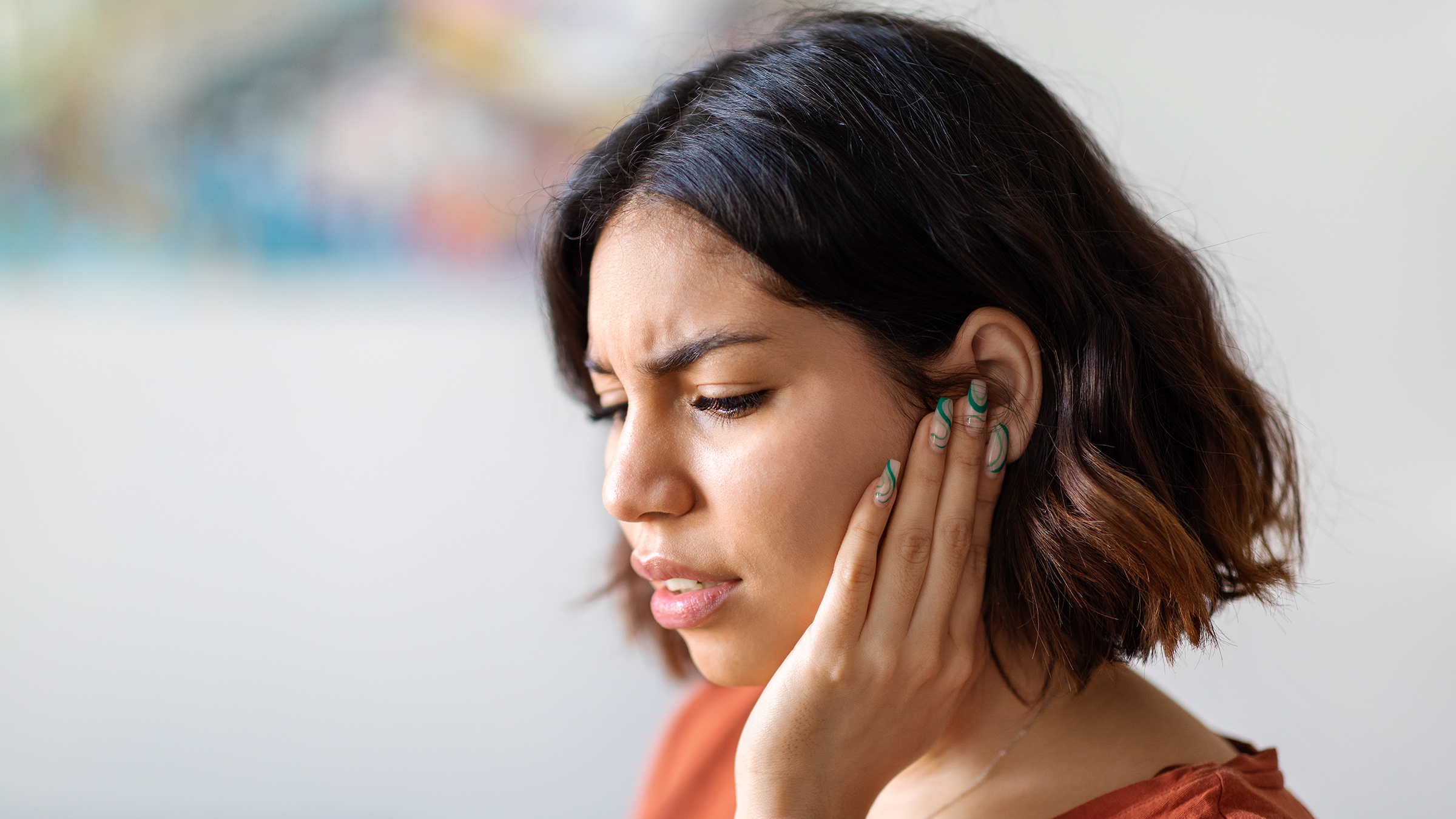 ear infection: young woman with earache 1479050692