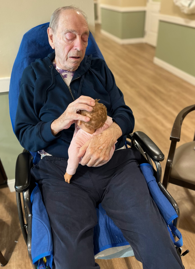David Rothman is pictured in his wheelchair holding his therapy baby doll.