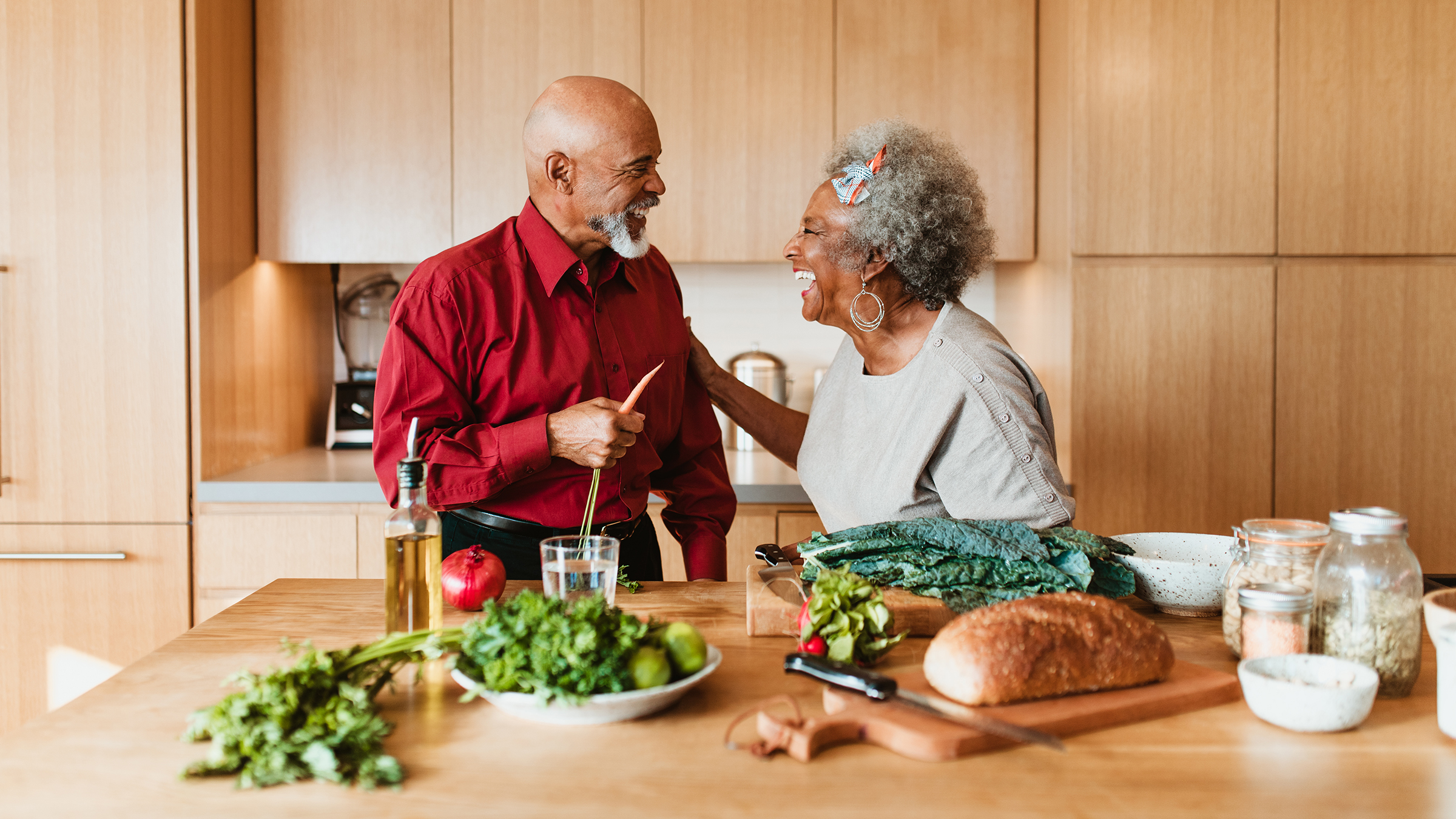A senior couple is prepping dinner in the kitchen. They are looking at each other and smiling and laughing.
alvarez/E+ via Getty Images