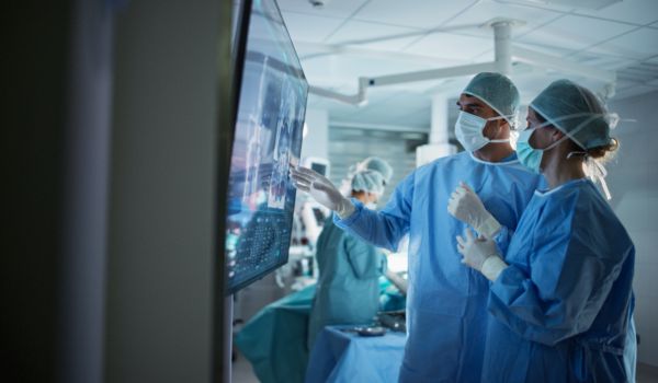 2 surgeons looking at and discussing how to succeed in cms team model