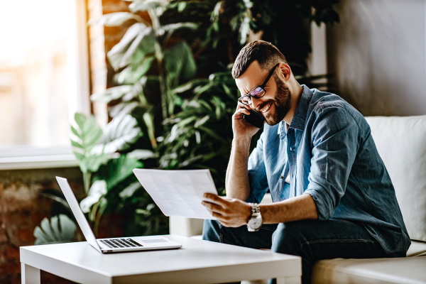 man talking on phone looking at billing statement