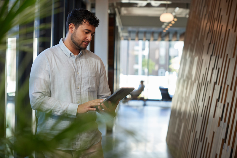 Man on ipad walking through apartment complex