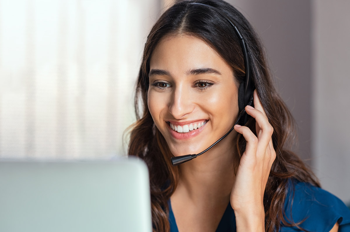 woman on headset looking at computer