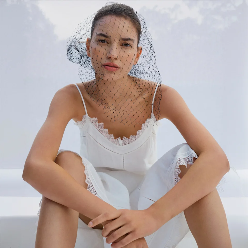 Model in a white lace camisole and net veil