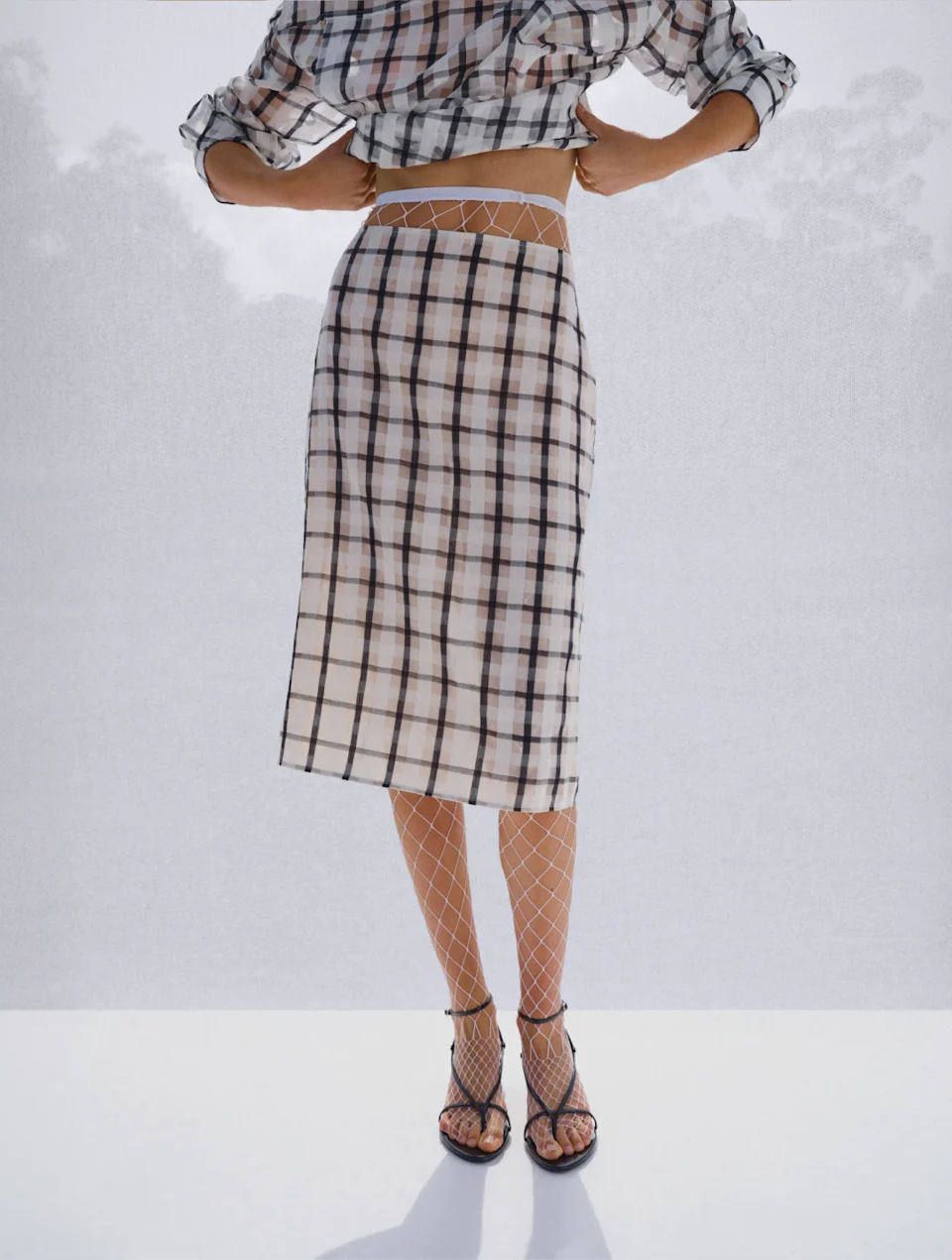 Model in a matching black and white check shirt and skirt