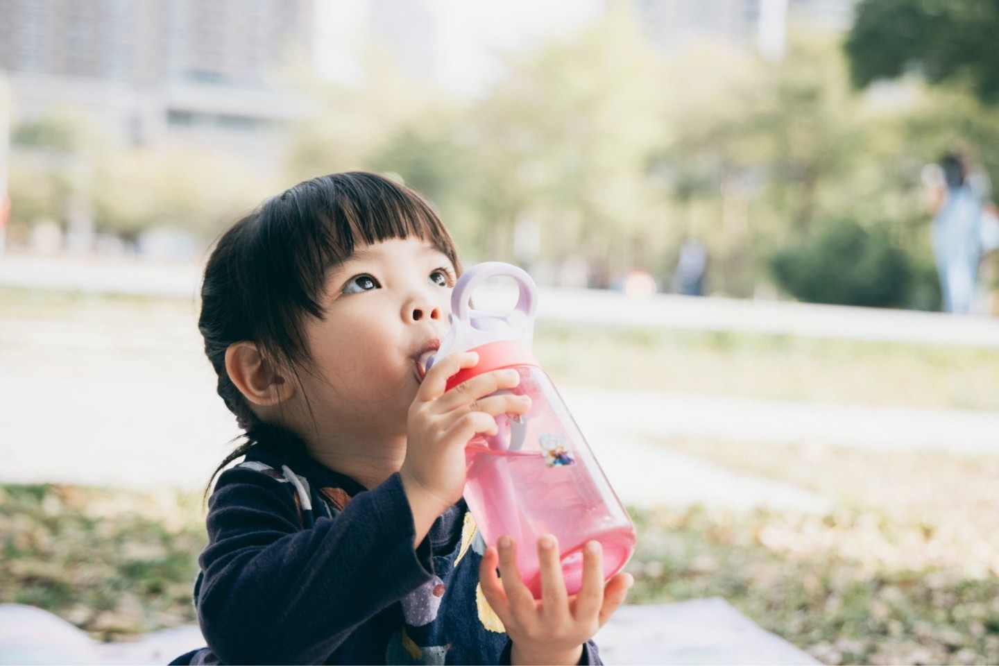 toddler drinking water from a straw cup