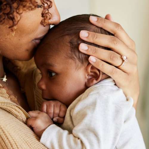 A mother kissing her child's forehead.